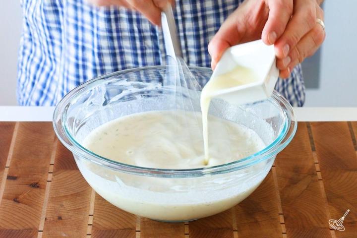 Someone whisking in melted butter into Dill French Crêpes batter.