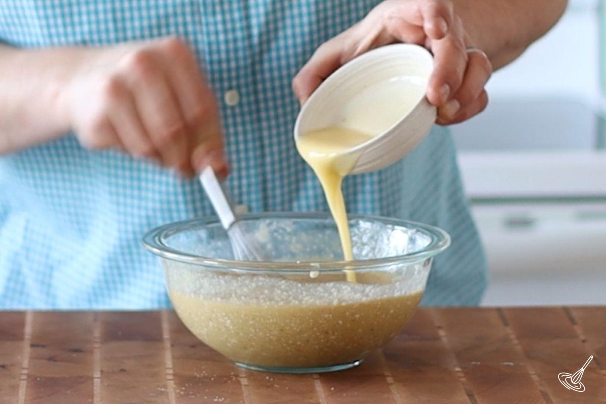 Someone pouring melted butter into a bowl.
