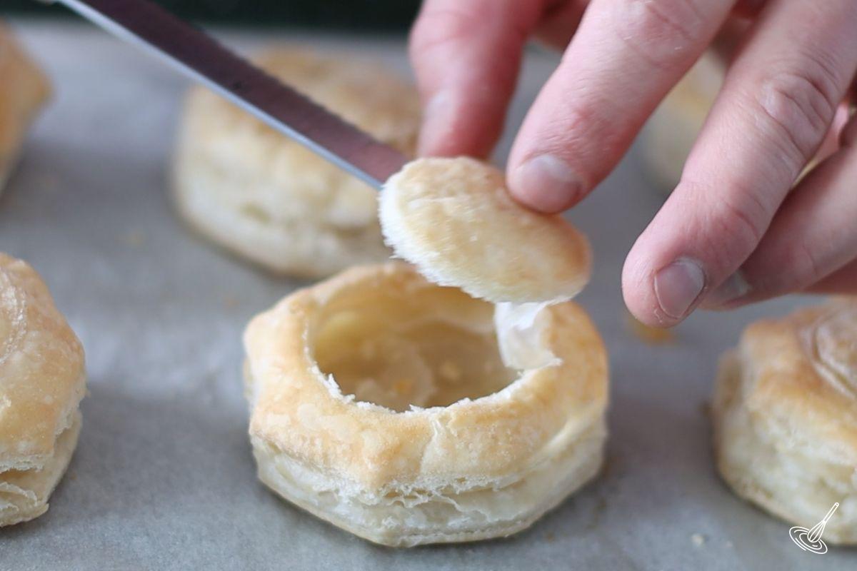 Someone taking the top off the baked vol-au-vent.