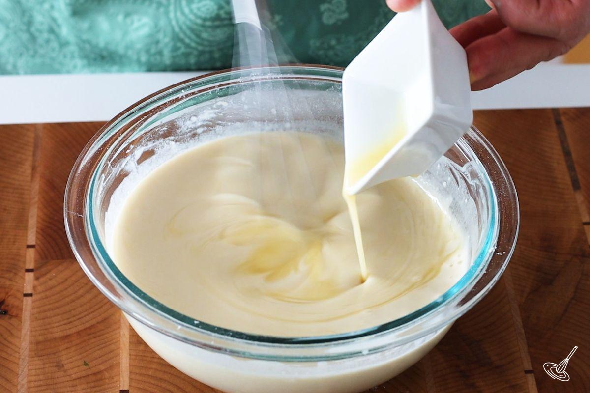 Someone whisking in melted butter into Pâte à Crêpes.