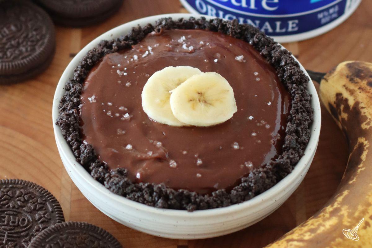 A banana chocolate tart garnished with banana slices and sea salt.