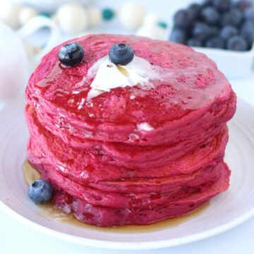Stack of Pink Beet Pancakes on a white plate.
