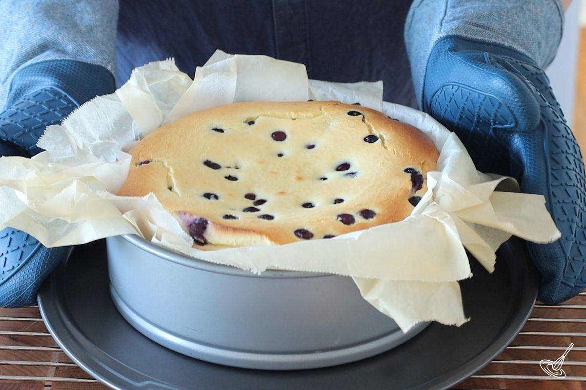A baked blueberry basque cheesecake on a cooking rack.