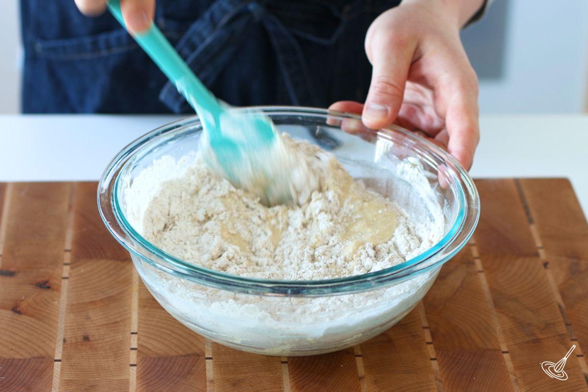 Someone using a spatula to mix muffin batter.