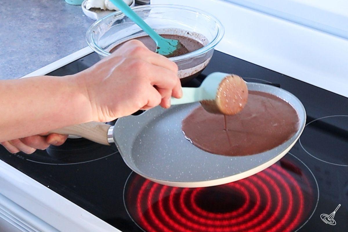 Someone pouring Chocolate French Crepes batter in a crepe pan.