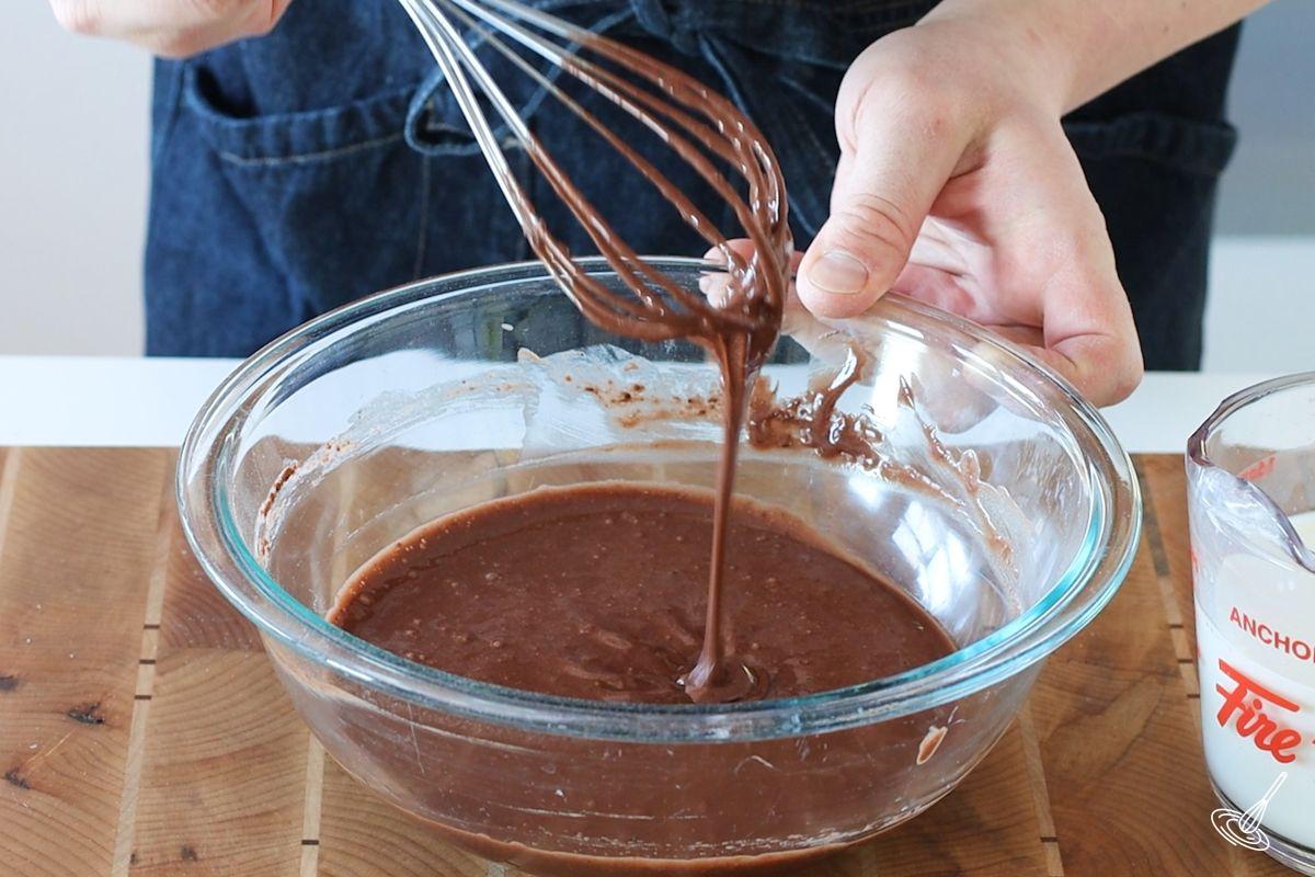 Someone whisking a chocolate batter.