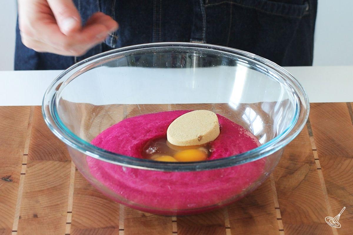 A large bowl containing beet puree, eggs, and brown sugar.