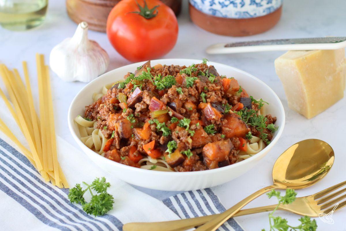 Aubergine Bolognaise pasta in a bowl, garnished with parsley.