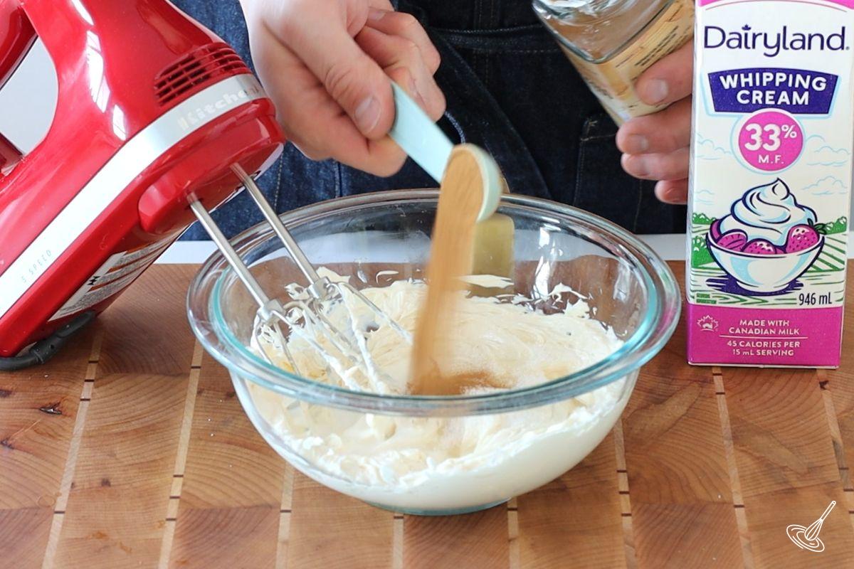 Someone adding instant espresso to a large bowl of cream cheese. 