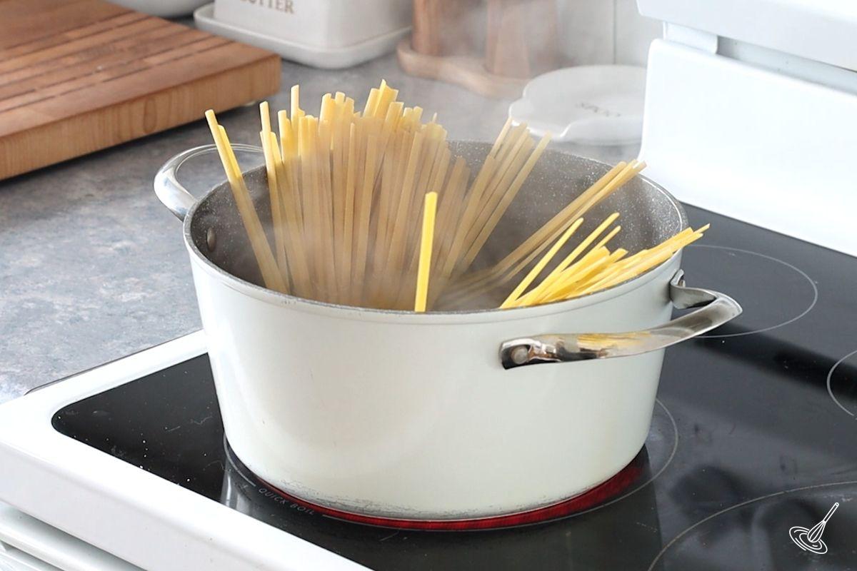 A large pot of water with pasta on the stove.