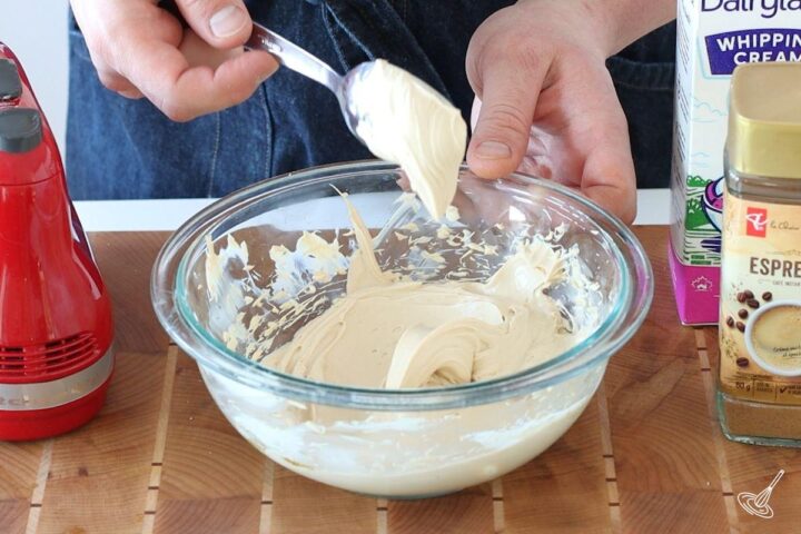 Someone scooping up a spoon of tiramisu coffee cream topping. 