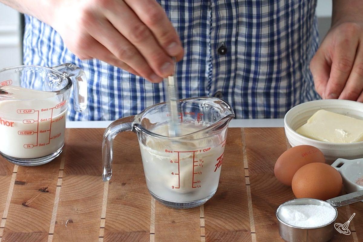 Someone mix yeast and sugar into warm water.