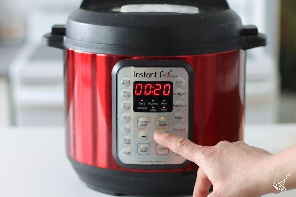 Someone setting an electric pressure cooker for 20 minutes. 
