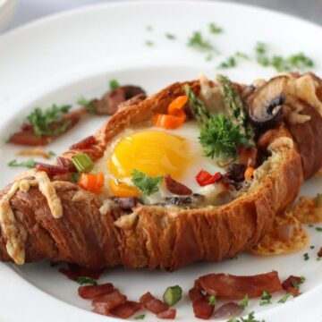 Croissant Egg Boat on a white plate.