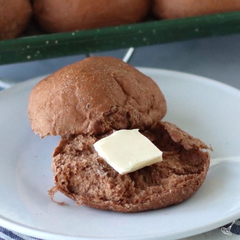 Rye Dinner Roll on a plate with butter.