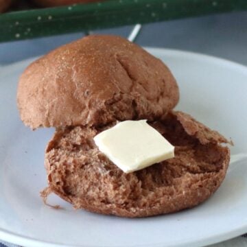 Rye Dinner Rolls on a plate with butter.