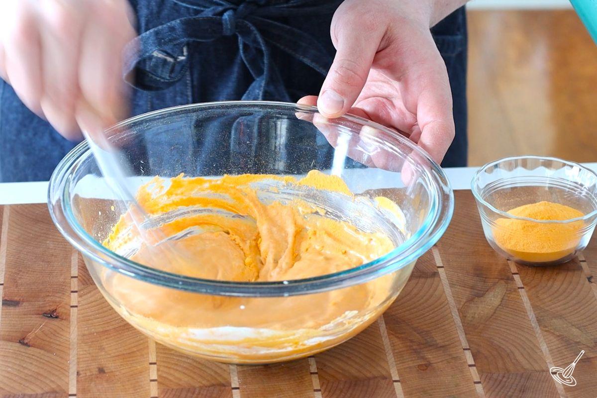 Someone whisking a cheesy salad dressing.