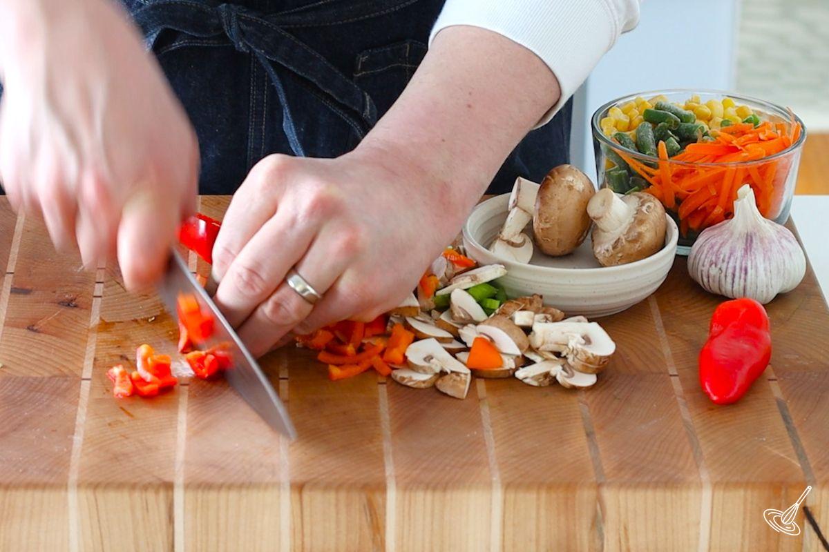 Someone cutting slices of bell pepper.
