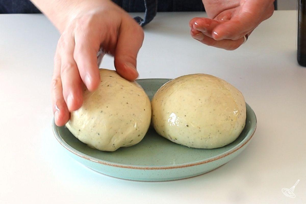 Two balls of pizza dough on small plate.