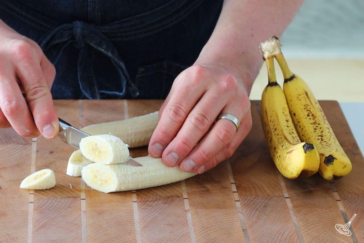 Someone slicing pieces of banana.
