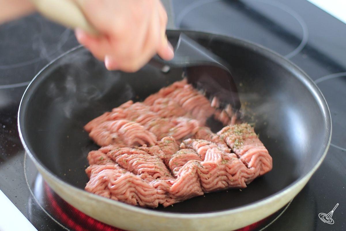 Someone cooking ground turkey in a frying pan.