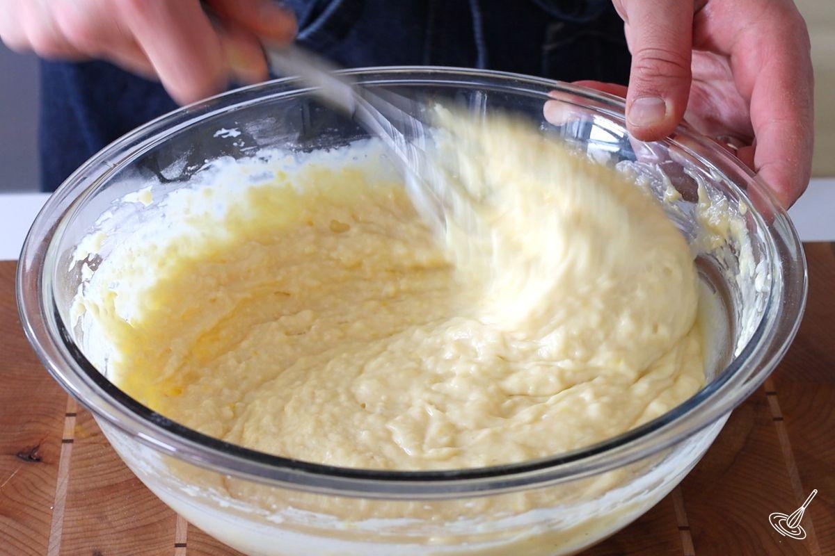 Someone using a whisk to mix a Bundt cake batter.