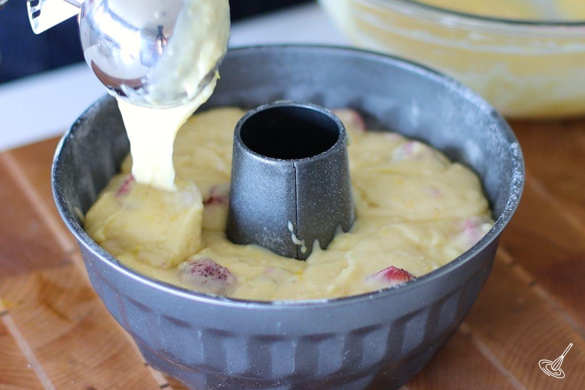 Someone pouring Strawberry Lemonade Bundt Cake batter in a Bundt pan. 