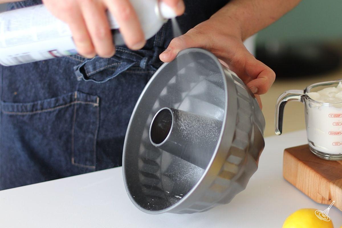 Someone greasing the inside of a Bundt pan.