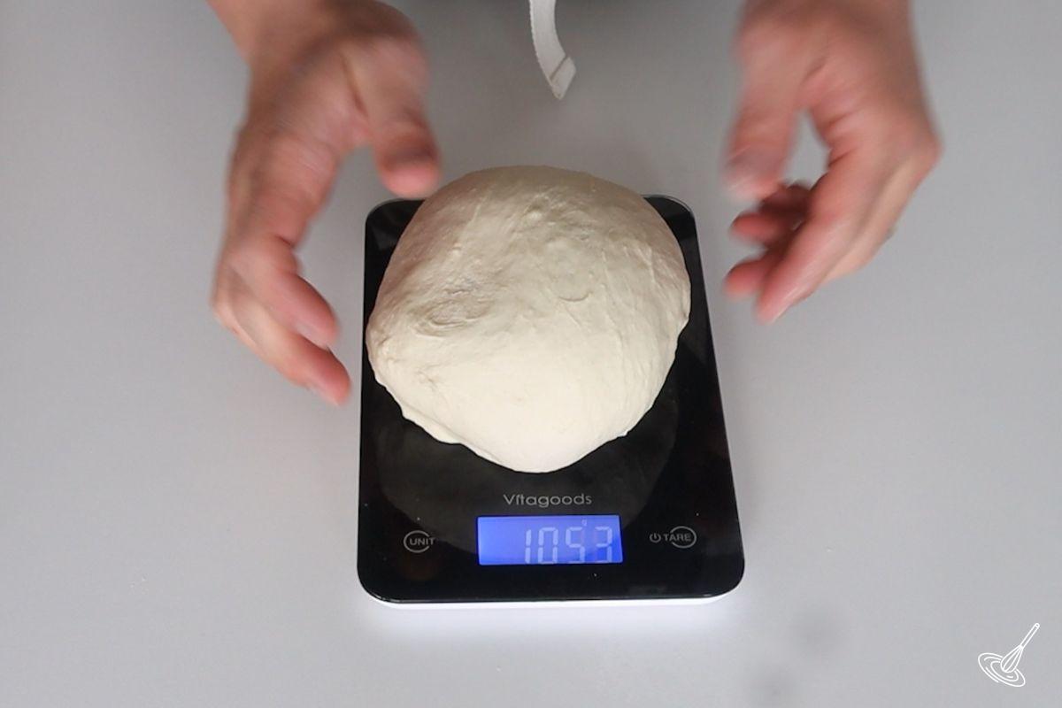 A ball of pretzel dough on a food scale.