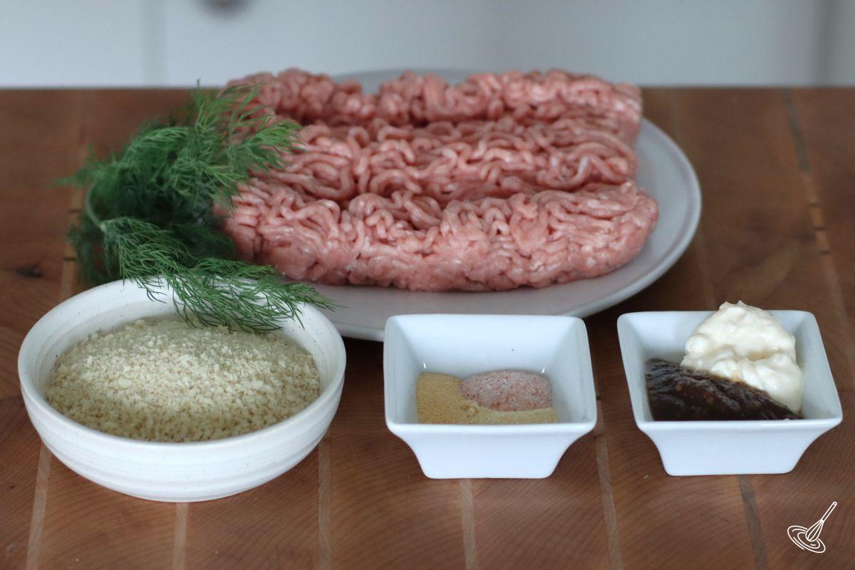 Ingredients on a cutting board, including ground turkey, panko crumbs, and seasonings.
