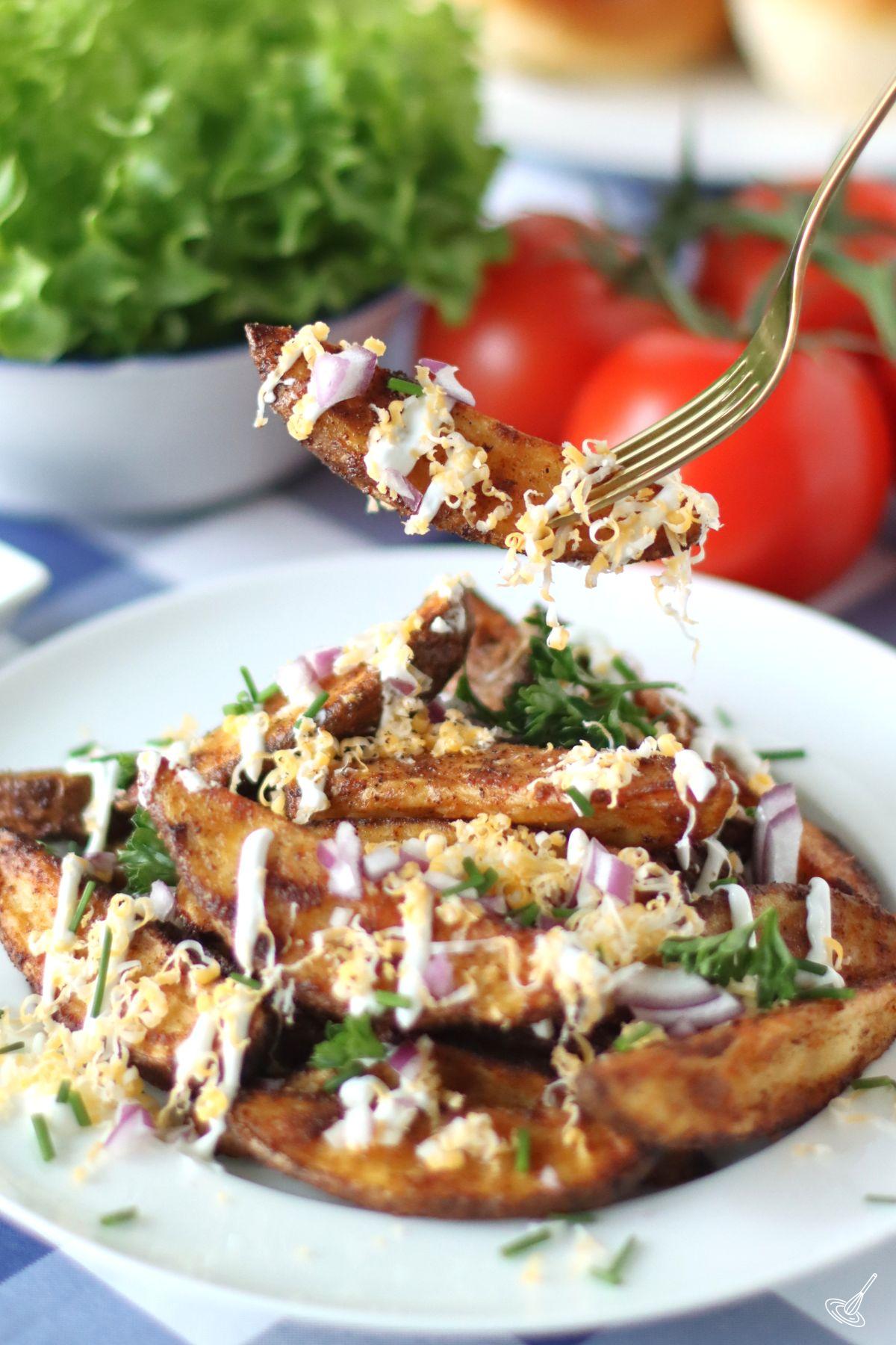 A loaded potato wedge on a fork.