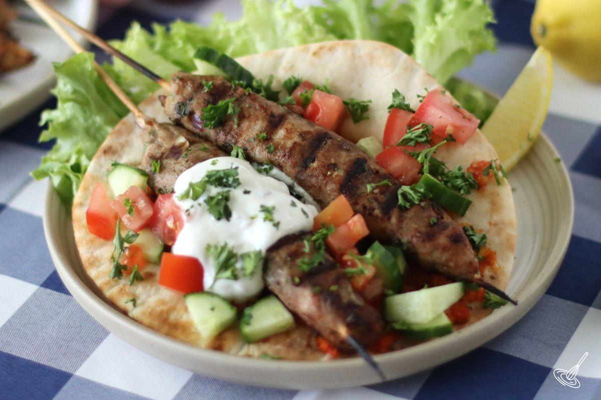 Cooked Ground turkey kofta skewers on a pita bread.