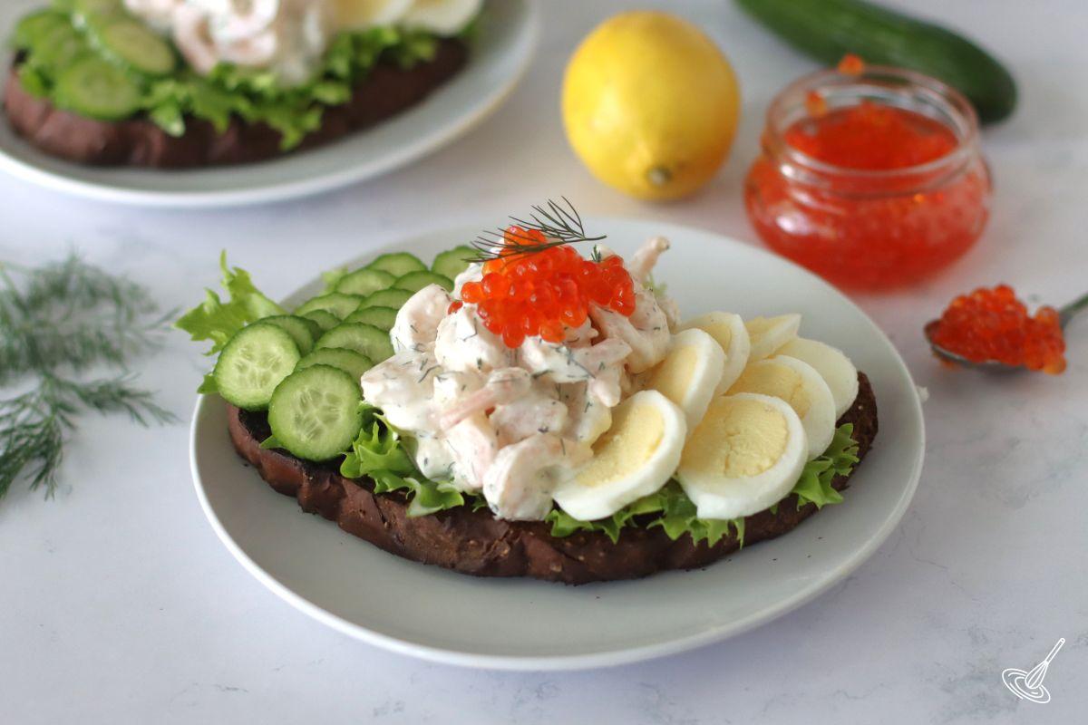 Swedish Shrimp Salad on top of a toast with lettuce, eggs, and cucumber. 