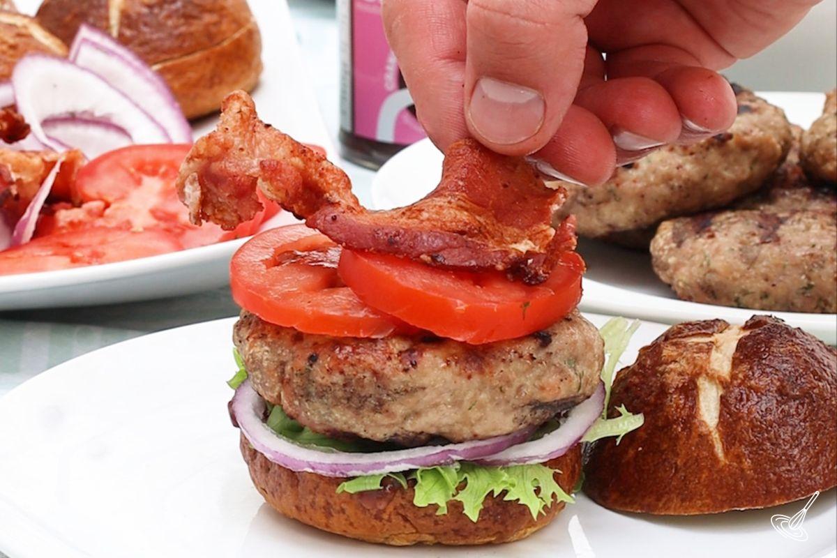 Someone assembling a turkey burger sliders.