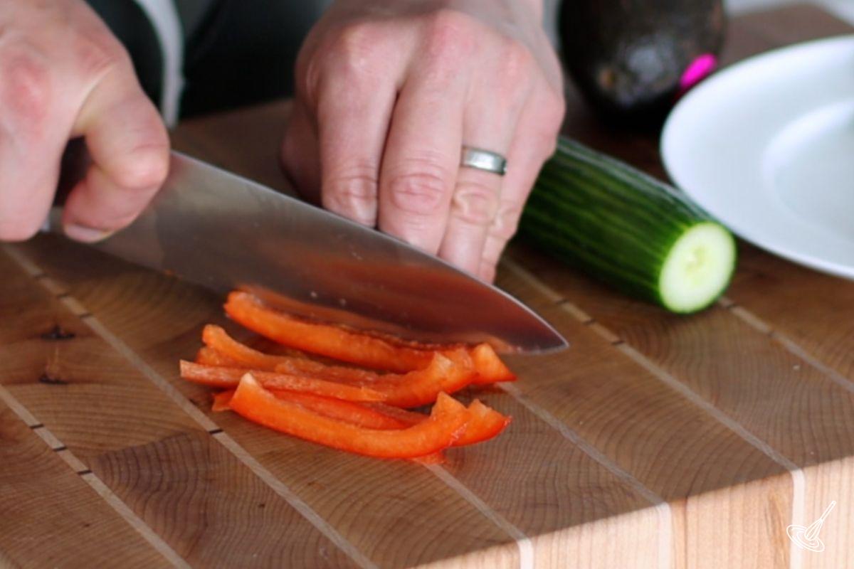 Someone cutting bell pepper in julienne. 