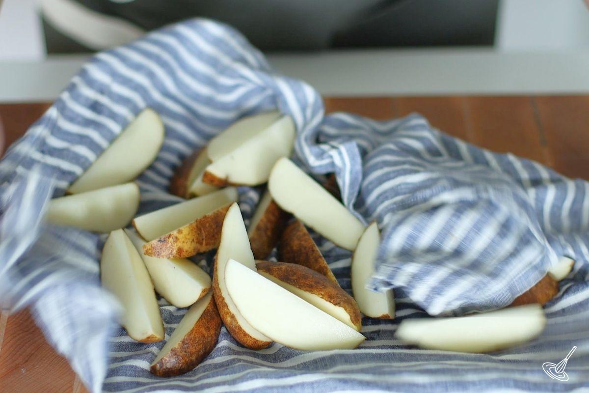 Potato wedges drying on a dish towel.
