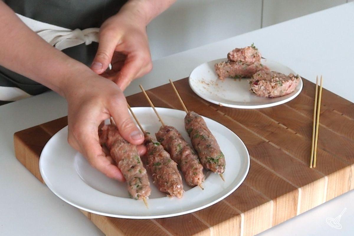 Someone shaping turkey kofta skewers.