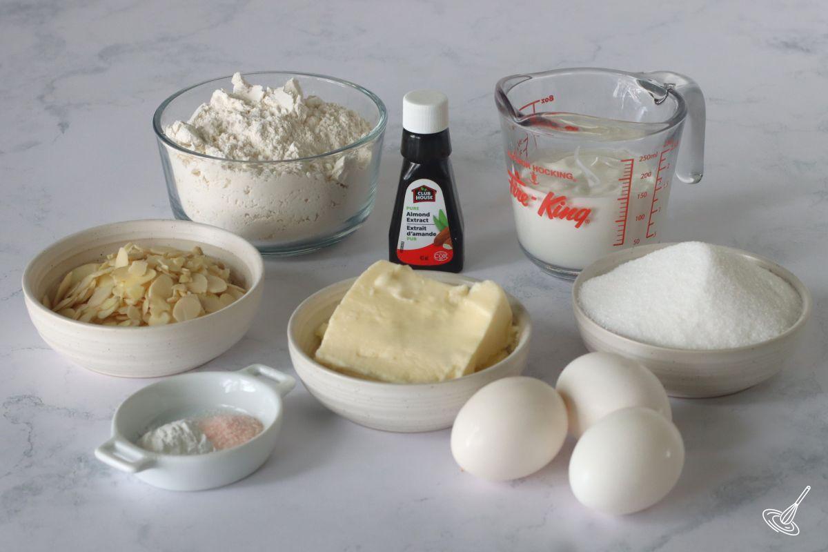 Ingredients on the counter including butter, almond, flour, yogurt, sugar, and eggs.