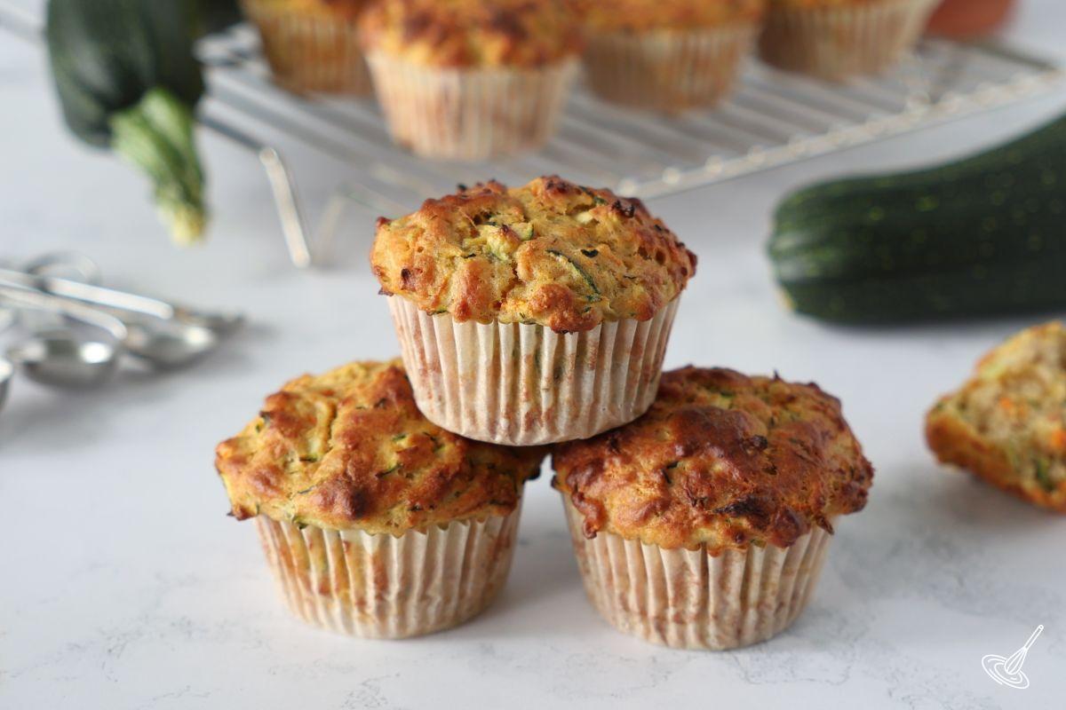 Three Carrot cake zucchini muffins on a kitchen counter. 