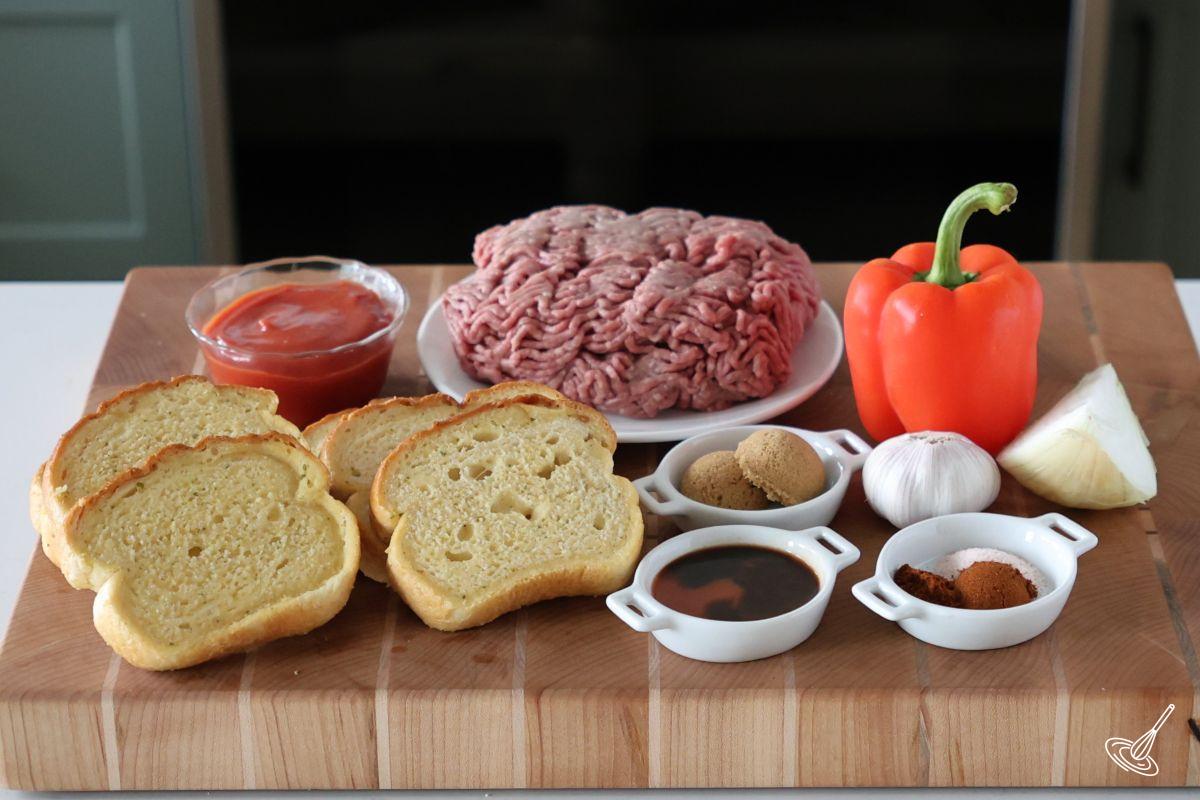 Ingredients on a cutting board to make sloppy joes, including texas toast, ground been and seasoning.