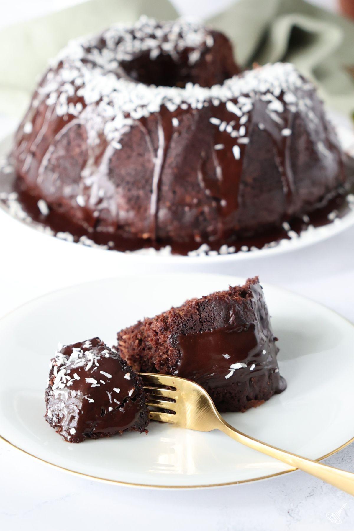 A slice of Chocolate Zucchini Bundt Cake on a plate with a fork.