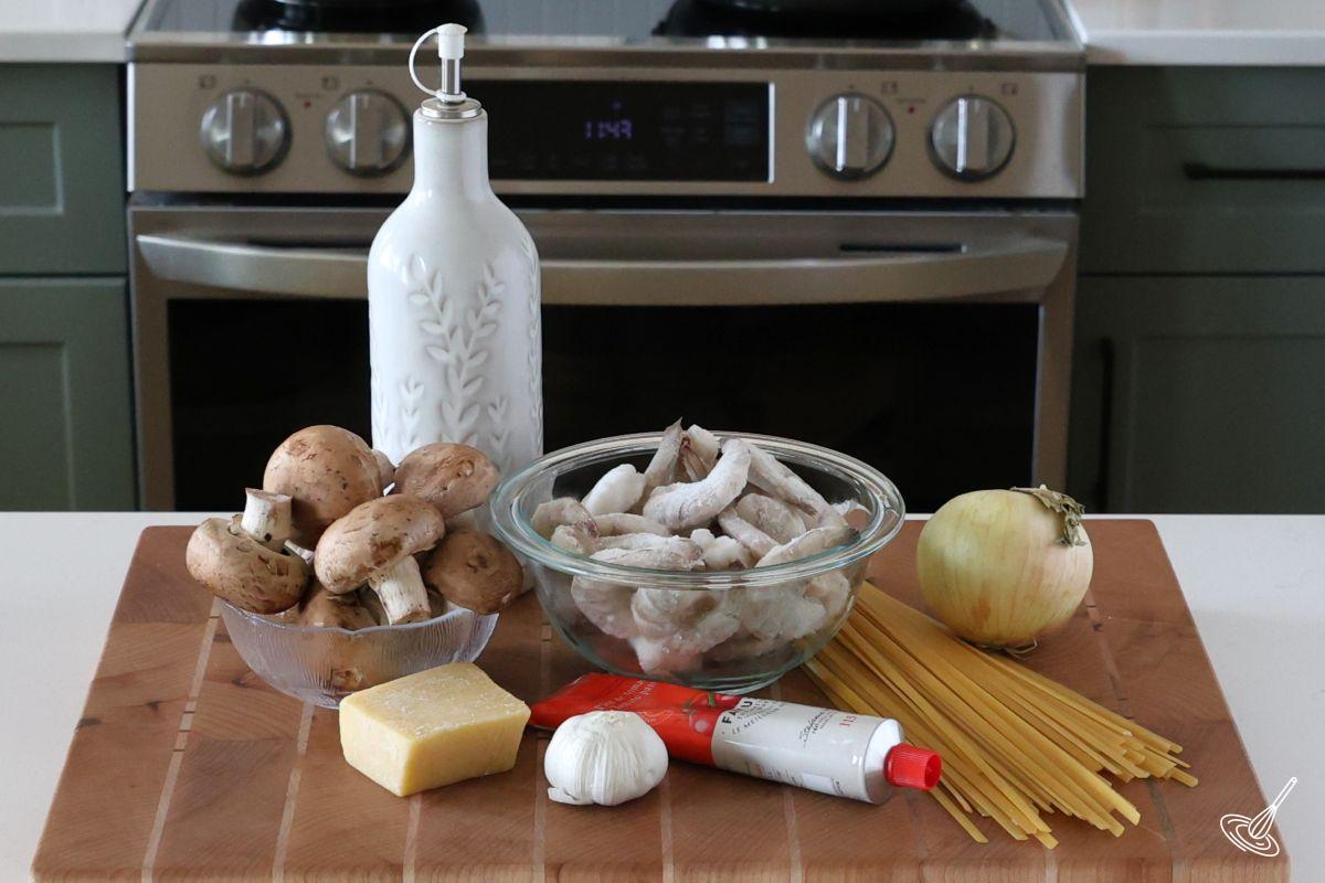 Ingredients on a cutting board to make Shrimp Mushroom Pasta. 