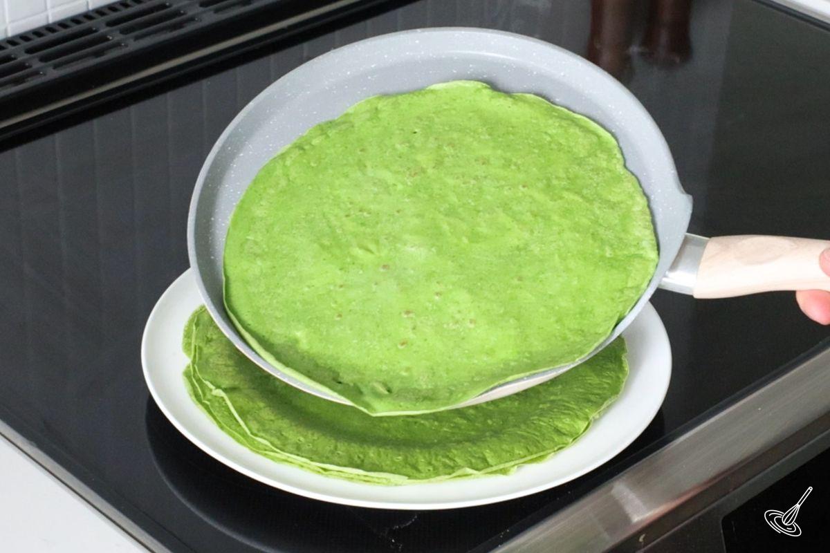 Someone removing a crepe for a pan. 