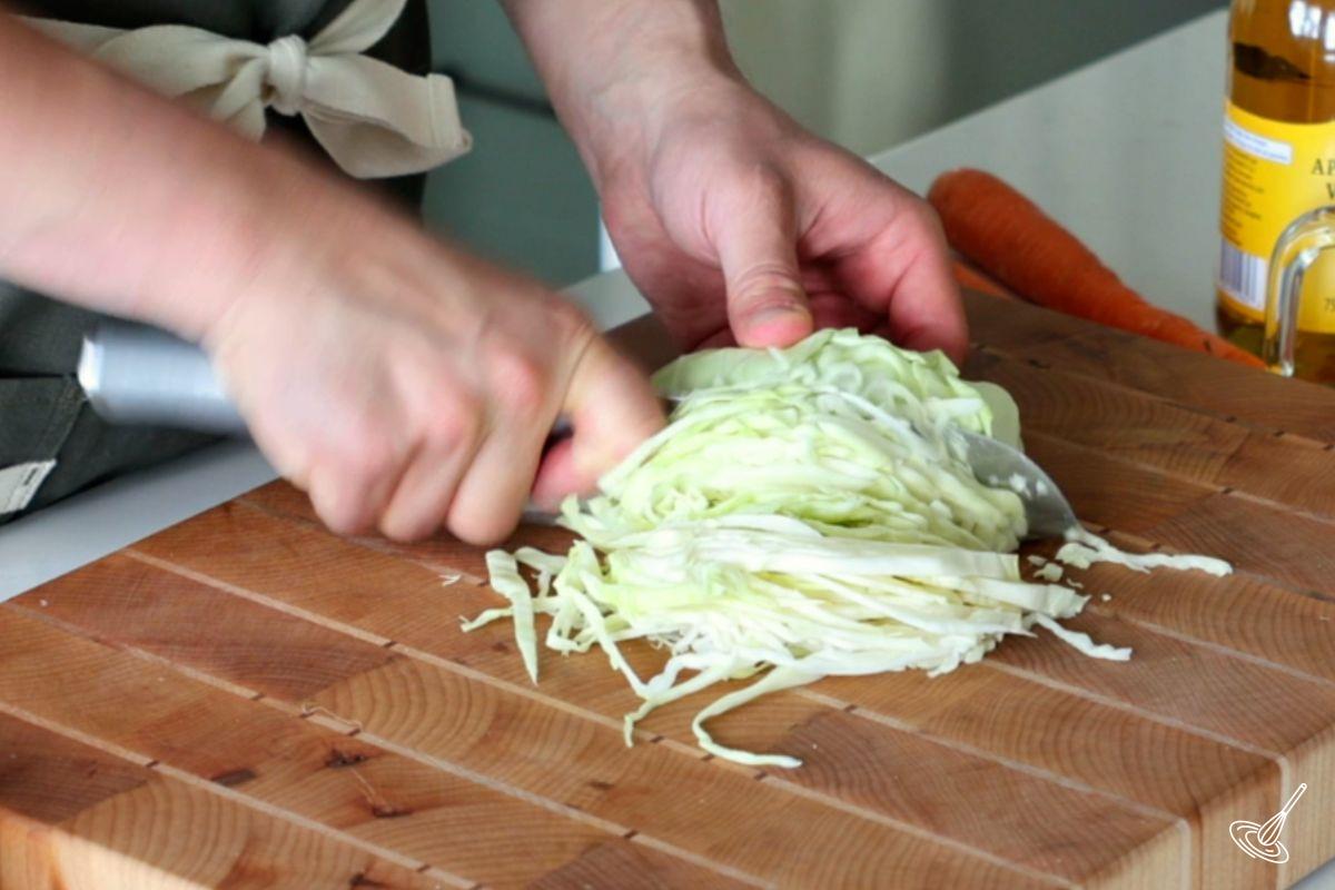 Someone shredding cabbage with a knife.