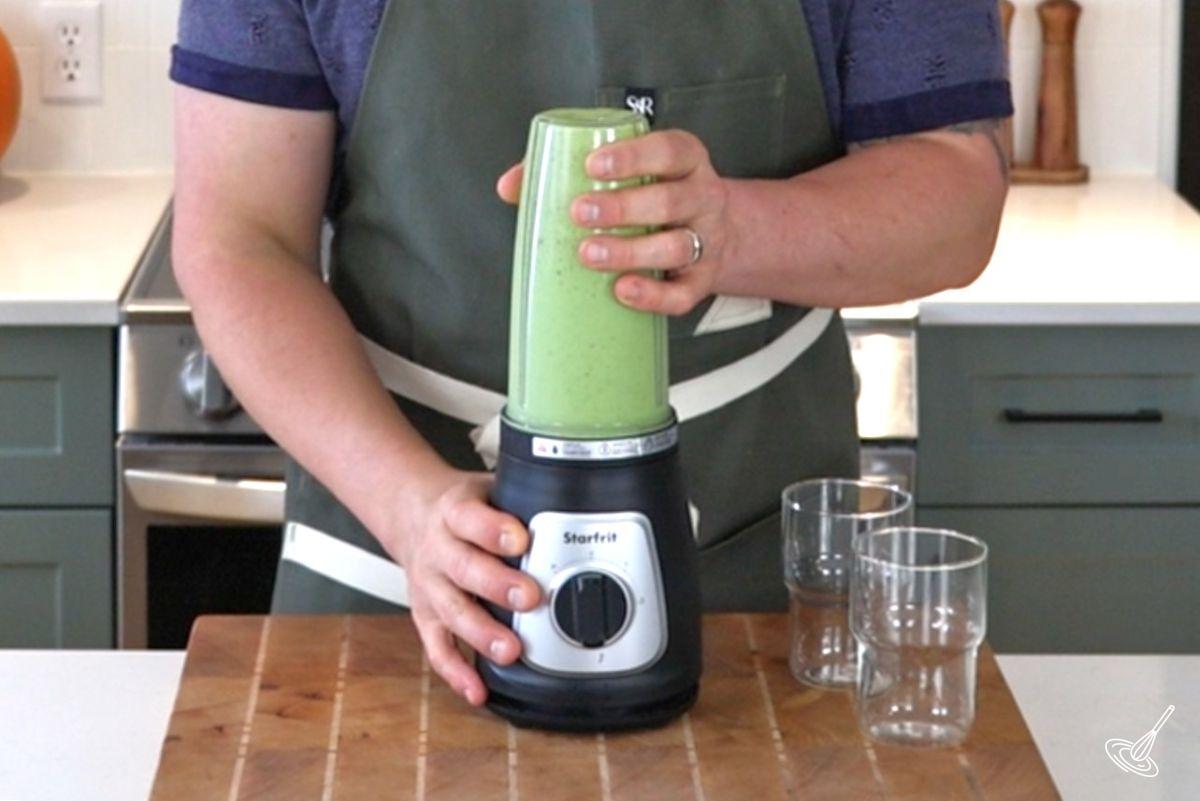 Someone using a blender to make a Swiss chard smoothie. 