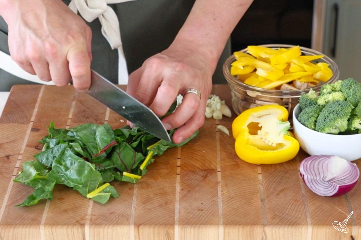 Someone chopping up Swiss chard into bite-sized pieces. 