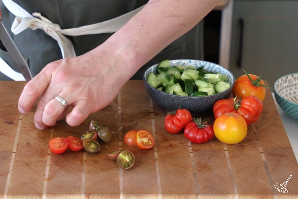 Someone cutting cherry tomatoes in half.