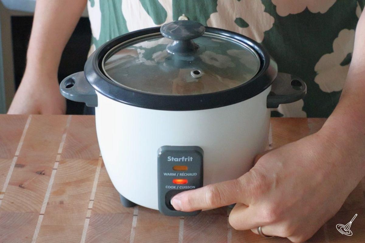 Someone turning on a rice cooker.