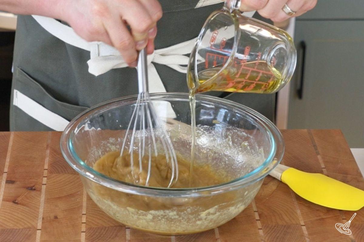 Someone whisking in avocado oil into a bowl.