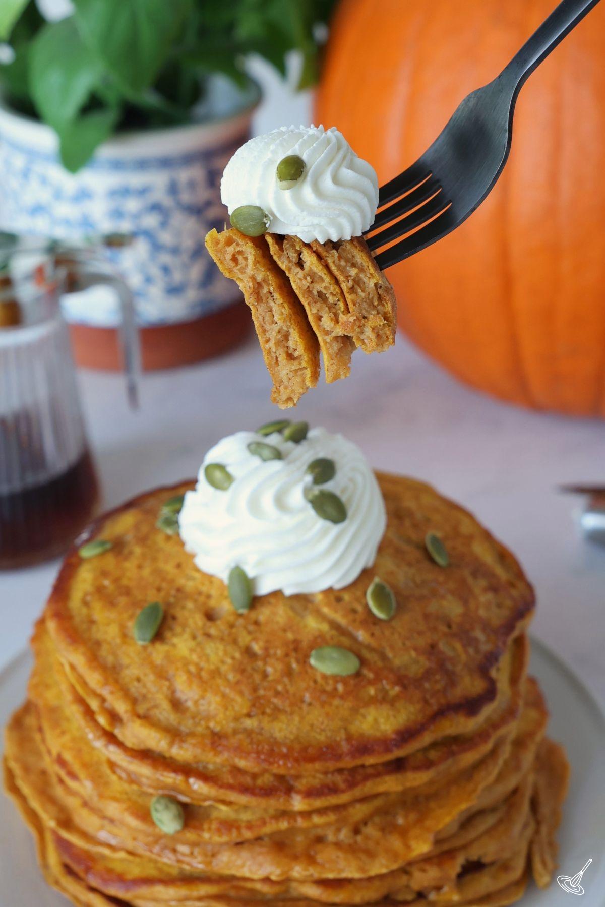 Someone holding a forkful of pumpkin pancake.